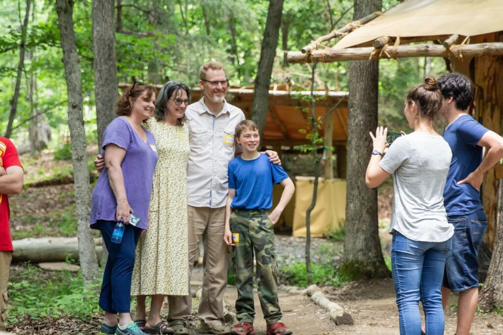 camper and his parents getting a picture taken together in campsite